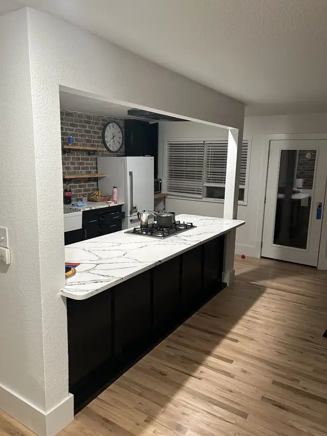 Black painted kitchen island with white quartz counters