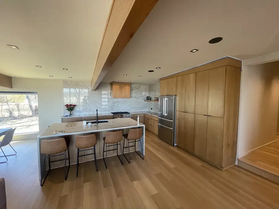 Modern open kitchen with maple cabinetry and painter’s tape along the ceiling line