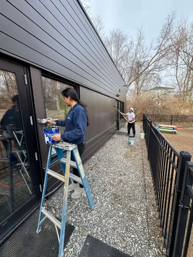 Portrait view of the Quality Pro crew on the same glass-front wall job
